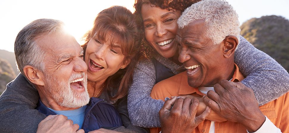 Smiling Senior Friends Having Fun Walking In Countryside Together